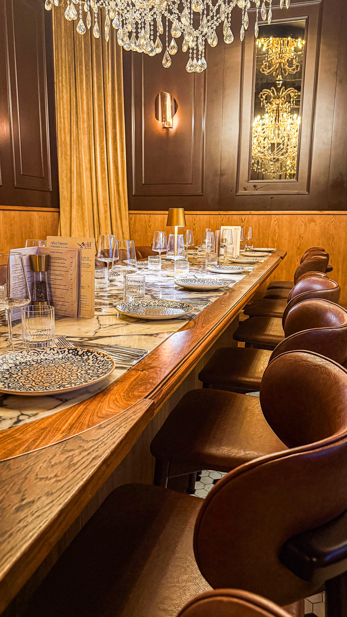 The private dining table seen down its length, set with menus and glassware